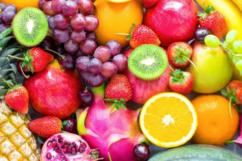 Un assortiment coloré de fruits frais : ananas, fraises, raisins, kiwis, pommes, oranges, bananes, poires, fruits du dragon et grenades. Une excellente source de fibre pour une alimentation saine.
