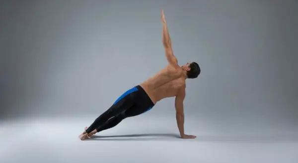 Homme en planche latérale, bras levé, pour perdre poignée d'amour. Musculature dorsale et abdominale visible.