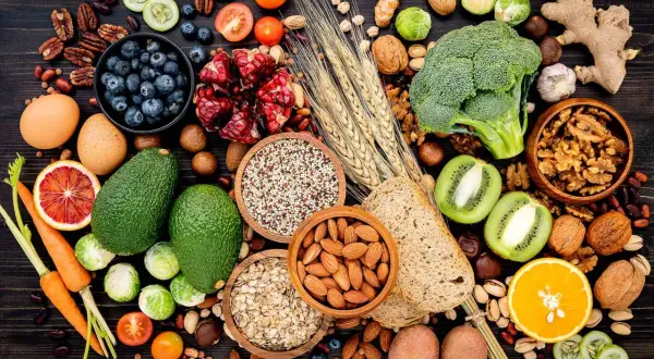 Assortiment de fruits, légumes, noix et céréales, des aliments riches en fibres insolubles pour une alimentation équilibrée.
